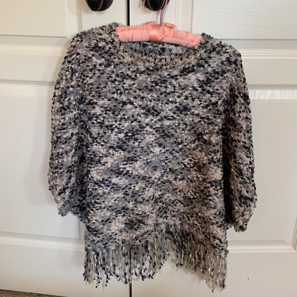 Fringed poncho type pull on sweater.